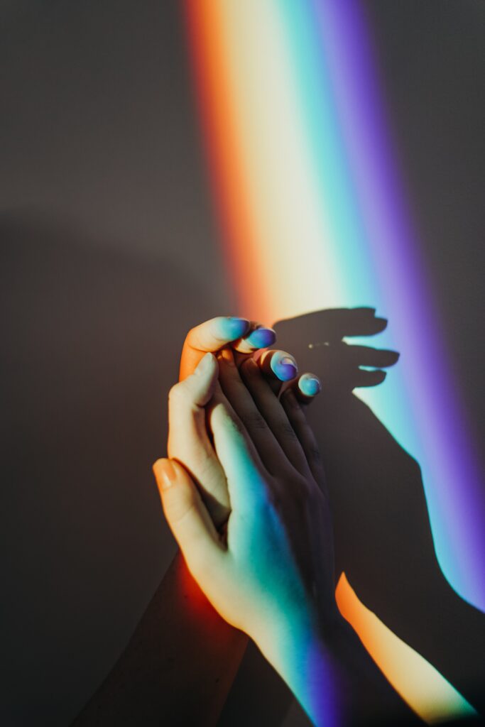 two hands on a rainbow background